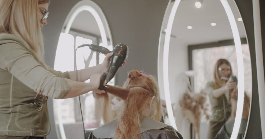 Hair drying of a woman in the hairstyling studio, new hairstyle in making, trucking Royalty-Free Stock Footage #1109336097