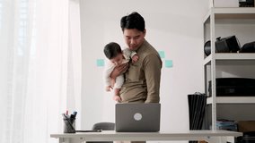 Happiness Asian father creative freelancer carrying his son while working at home. Technology communication and lifestyle concept.