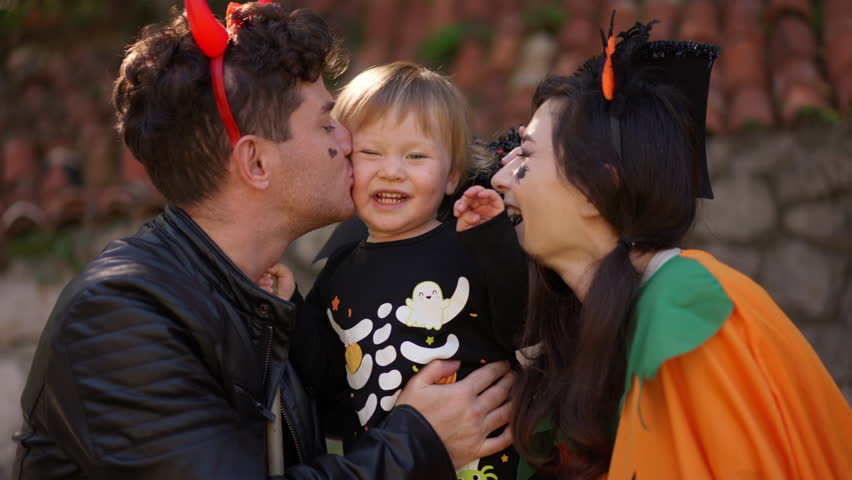 Close up portrait of happy Multinational family with a child dressed up for Halloween in costumes and weighed play together the background of Halloween props, bats, pumpkins, skulls, spiders, brooms Royalty-Free Stock Footage #1109346507