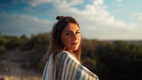 Slow motion bokeh shot of a model watching the sunset on a hillside
