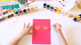 Child making homemade greeting card from paper. Gift for Mothers day, Fathers day, Birthday or Valentines day.  Kid craft. Home Education  - Powered by Shutterstock - Get 15% off with code: PIKWIZARD15