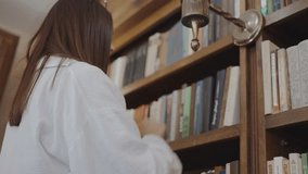 Girl takes book from bookshelf