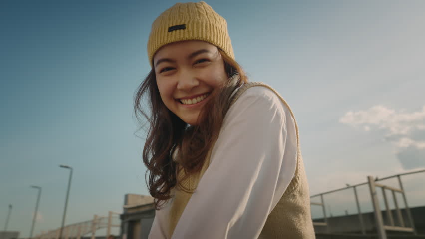 Young Gen Z girl asia people curly brown hair, face, eye smile in blue sky sun light lens flare. Teen urban city life happy joy of future hope enjoy warm time relax sunset. Good mental health teenage. Royalty-Free Stock Footage #1109359017