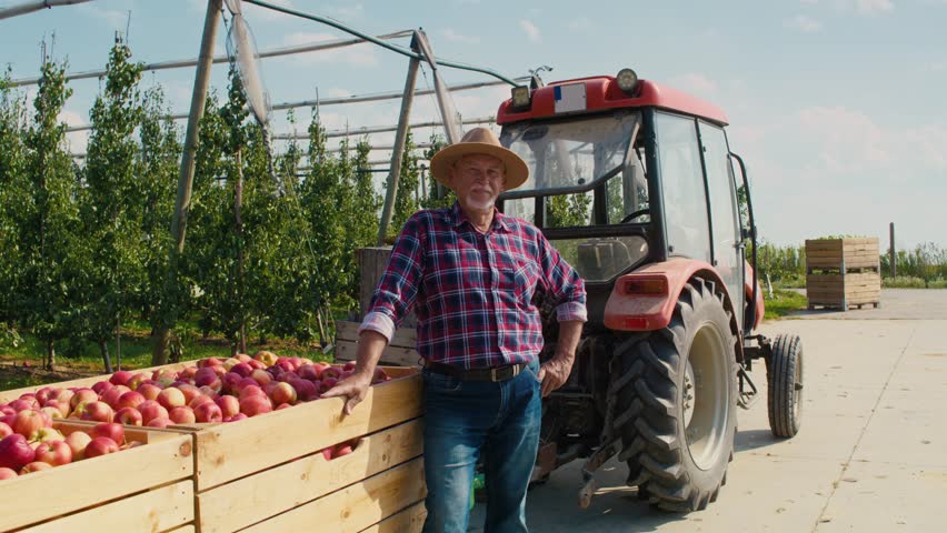 Portrait of senior farmer next to tractor. Shot with RED helium camera in 8K.  