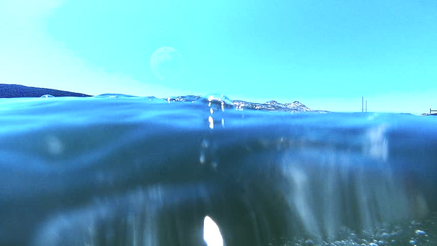 Explore the underwater world with slow-motion footage of air bubbles ascending from the ocean floor to the water surface, illuminated by sunlight. Great for an abstract backdrop.