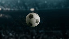 A soccer ball floats in the air as grass particles fly around.football ball on a blurry stadium in the background. - Powered by Shutterstock - Get 15% off with code: PIKWIZARD15
