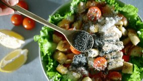 chia seeds falling slow motion, close up video. healthy caesar salad cooking. tomato, chicken. cheese, crunchy croutons, romaine lettuce, olive oil, lemon