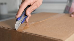 Male person hold clerical knife. Man cut mail box close up. Guy open new parcel. Hands unpacking postal package. Young adult unboxing e-commerce box. Client buy carton gift. Receiver unzip post pack. - Powered by Shutterstock - Get 15% off with code: PIKWIZARD15