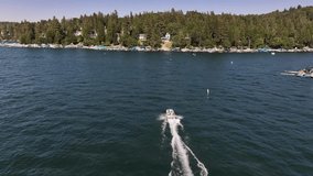 speed boat on lake arrowhead california driving fast towards lakeside homes to dock AERIAL DOLLY FOLLOW
