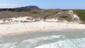 A drone footage of the sandy beach Frouxeira on a summer day by the Atlantic ocean, next to Valdoviño, spain 