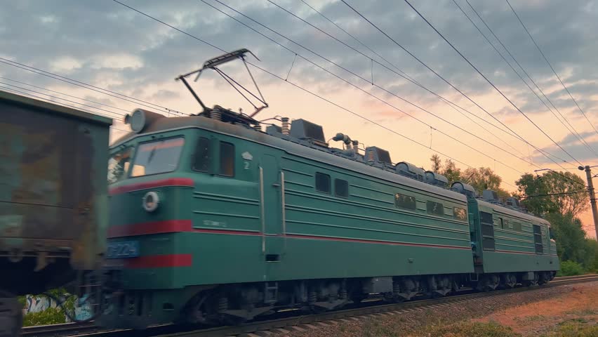 Freight train travels at sunset. Wide angle