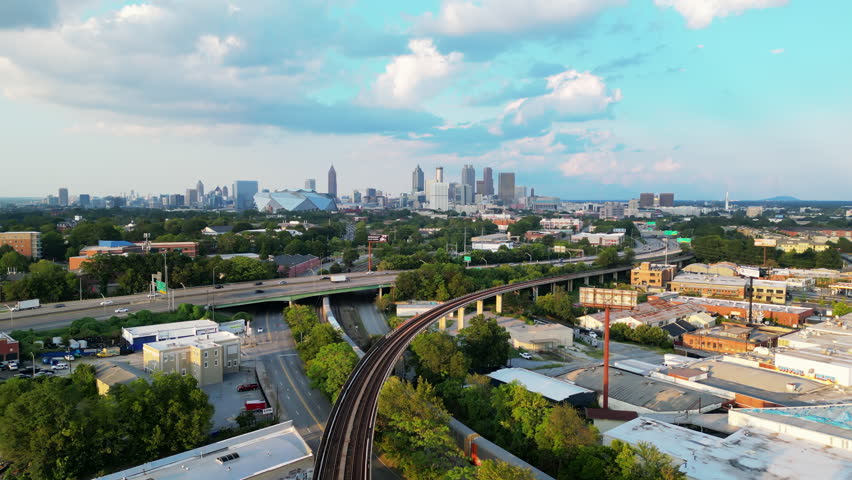 Aerial view of large city. Busy multilane highway and railway line on metropolis outskirts. Downtown skyscrapers in background. Atlanta, Georgia, USA