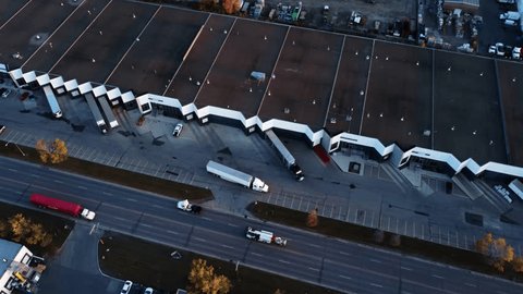 Стоковое видео: Semi-truck backing up towards warehouse loading dock. Drone view.