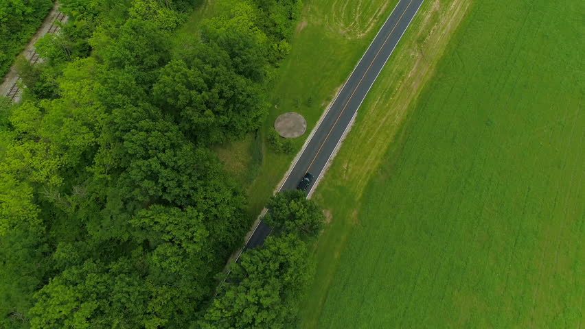 Aerial Forward Shot Of Limousine Moving On Road Amidst Green Landscape - Crawfordsville, Indiana Royalty-Free Stock Footage #1109413795