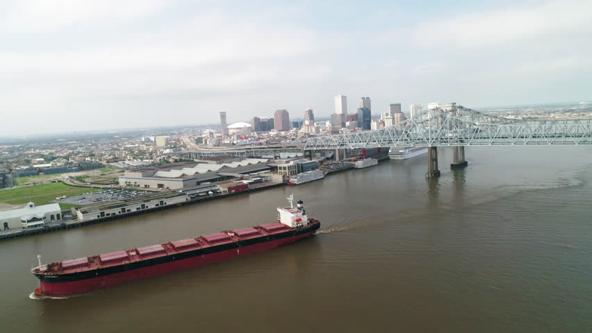 Aerial Panning Shot Of Ship On Mississippi River Under Bridge Against Sky - New Orleans, Louisiana