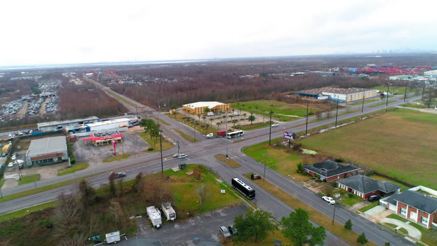 Aerial Forward Tilt Down Shot Of Vehicles On Roads Near Buildings In City Against Cloudy Sky - New Orleans, Louisiana