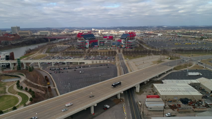 Aerial Tilt Down Shot Of Vehicles On Highway Near Nissan Stadium In City Against Cloudy Sky - Nashville, Tennessee