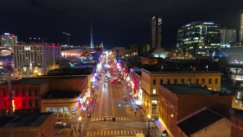 Aerial Forward Descend Shot Of Cars Moving On Roads Amidst Buildings At Night - Nashville, Tennessee