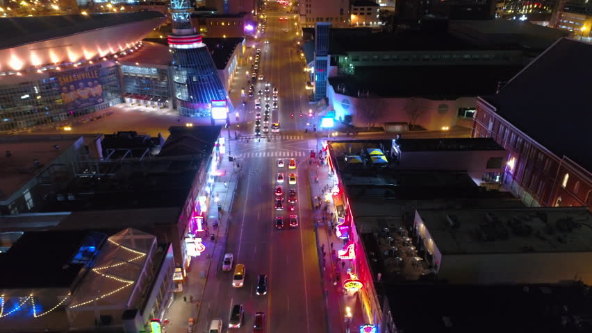 Aerial Forward Shot Of Traffic On Street Amidst Buildings In City At Night - Nashville, Tennessee