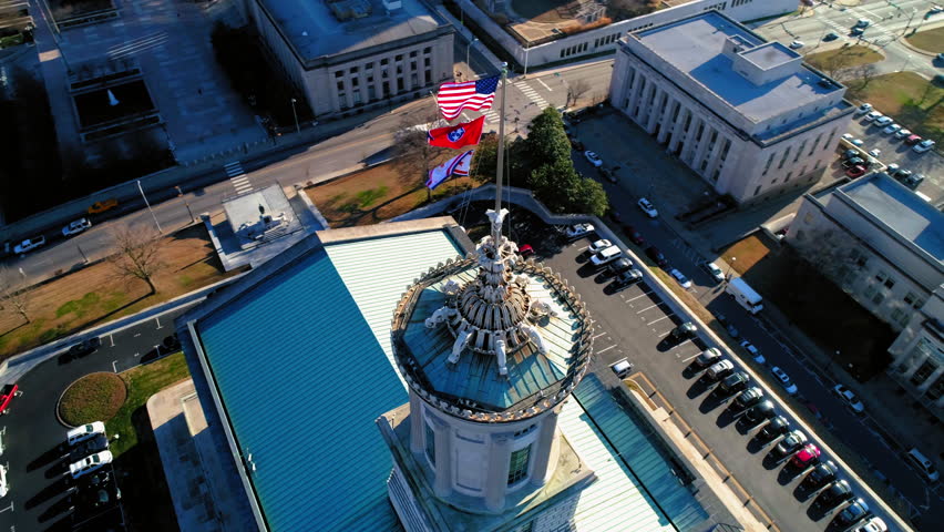 Aerial Panning Shot Of Flags On Tennessee State Capitol Nearby Buildings In City - Nashville, Tennessee