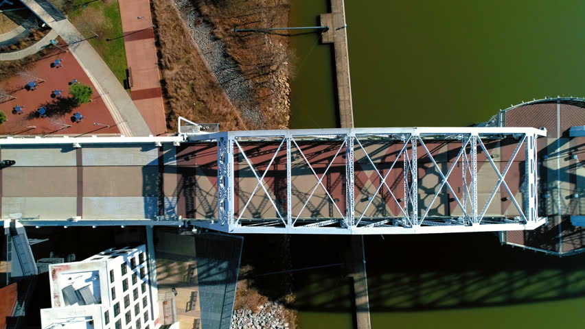 Aerial Top Panning View Of John Seigenthaler Pedestrian Bridge On River During Sunny Day - Nashville, Tennessee Royalty-Free Stock Footage #1109415181
