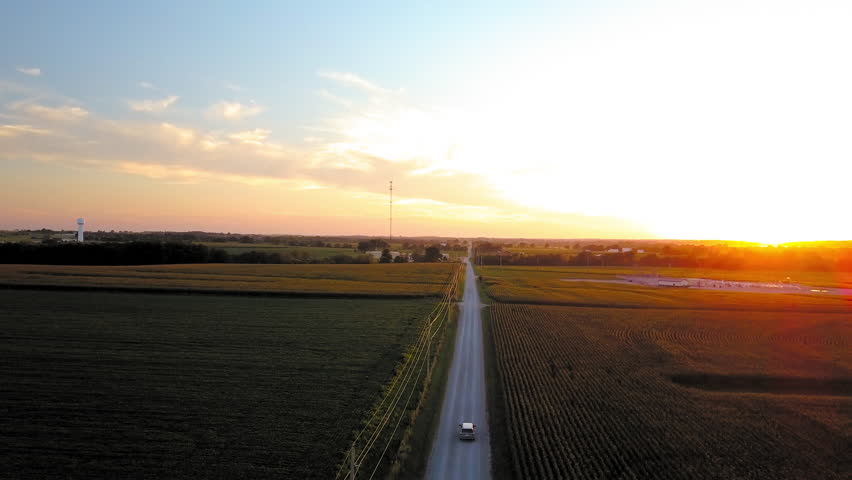 Aerial Tilt Down Shot Of Vehicle Moving On Dirt Road In Farm During Sunset, Drone Flying Over Rural Landscape - Kansas City, Missouri