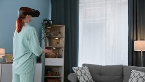 virtual communication, young woman in 3D reality glasses talking to family via video call while standing in a cozy room