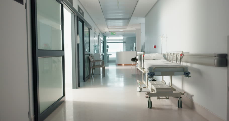 Healthcare, hospital and empty hallway with bed for medical care, health insurance and help in surgery. ER, emergency and lobby at clinic with stretcher for wellness, service and support in medicine. Royalty-Free Stock Footage #1109431299