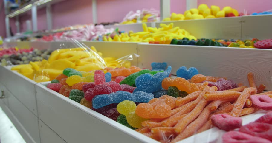 A lot of colorful fruit gummies lie in wooden boxes in a candy store. Delicious and beautiful bright treats for children. Royalty-Free Stock Footage #1109446801