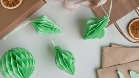 Female hands unfold paper Christmas honeycomb ornaments. Handmade foldable plastic free decor. Concept of winter creativity crafts. Trendy eco DIY. Scandinavian Modern decoration, minimalist. Top view - Powered by Shutterstock - Get 15% off with code: PIKWIZARD15