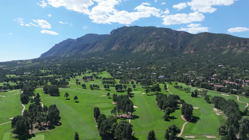 Colorado Springs Golf course. Stunning mountain landscape panorama during sunny day, fluffy cloud.