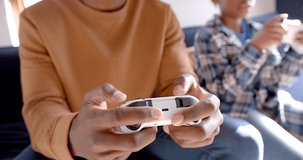 African american father and son playing video games at home, slow motion. Lifestyle, free time, childhood, communication, entertainment, family, togetherness and domestic life, unaltered.
