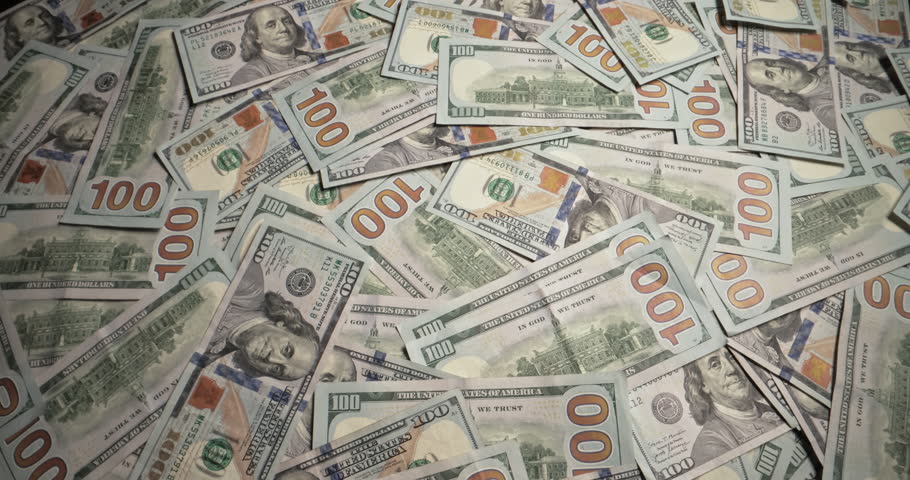 Bunch of dollar bills blows off table. One hundred dollar bills 100 usd money cash on dark wooden table blown away by wind. Bankruptcy insolvency business finance crisis failure crash concept.