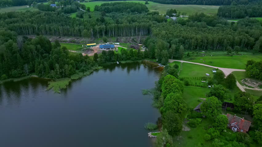Forest Logging Cut Around Newly Built House Surrounded by Green Trees and a Lake in Latvia.