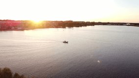 Aerial footage of a boat sailing on the Noordenplassen lake during sunset in Almere, Netherlands. 4k video