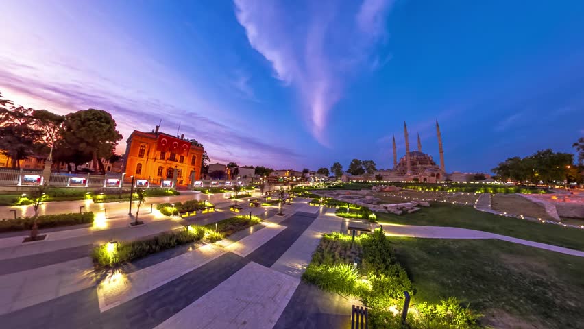 Evening falls over Edirne, Turkey, painting picturesque cityscape. Eski Ulu Old Mosque and Selimiye Mosque in Selimiye Park stand against twilight sky, accompanied by iconic Architect Sinan statue