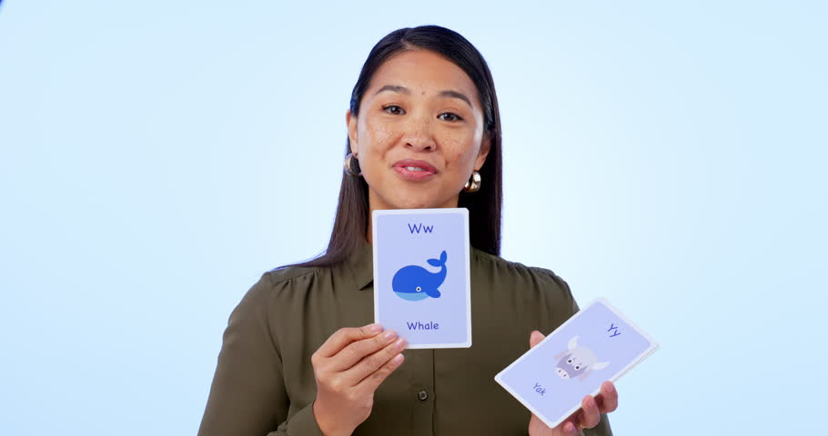 Woman, teacher and cards for education, smile and instructions on blue studio background. Display, lesson and teach for development, educator and vocabulary to study, words and learning language Royalty-Free Stock Footage #1109480855