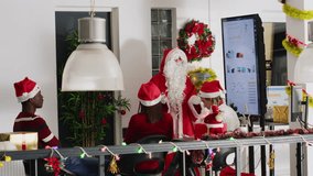 Manager dressed as Santa during Christmas season holding team meeting, presenting financial graphs on digital screen. Team leader in festive decorated office motivating workers - Powered by Shutterstock - Get 15% off with code: PIKWIZARD15