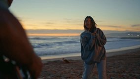 Young lady enjoying music dancing at sunset beach. Anonymous man playing guitar serenading at twilight coastline. Cute woman listening song moving body at sandy shoreline. Romantic couple evening date - Powered by Shutterstock - Get 15% off with code: PIKWIZARD15