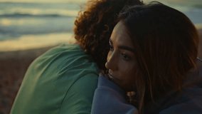 Sad girl embracing boyfriend at evening coast closeup. Unrecognizable curly guy supporting girlfriend hugging at ocean nature. Thoughtful young woman face bonding to man chilling together at seashore  - Powered by Shutterstock - Get 15% off with code: PIKWIZARD15