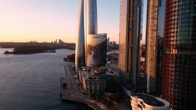 Sydney, Australia: Aerial drone footage of the stunning Sydney harbor with the iconic bridge with a revealing motion behind the new skyscrapers in Darling Harbor in Sydney at sunset. 