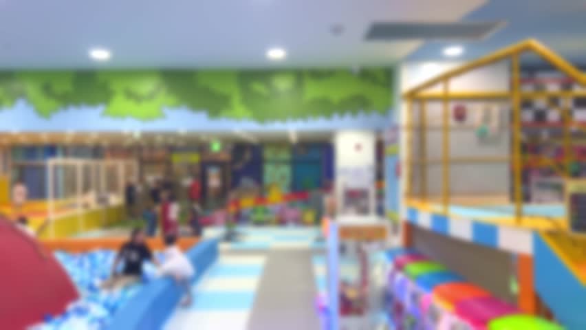 Children and parents having a great time at playplace, blured