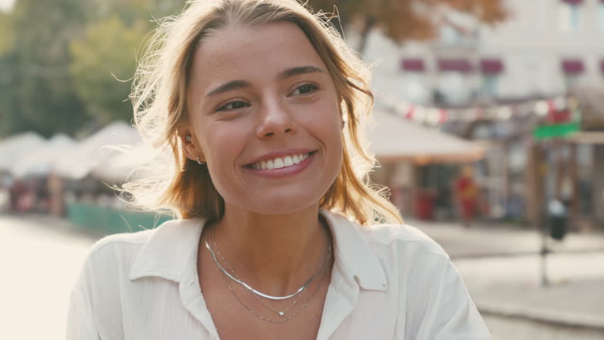 Woman striking confident poses while seated on motorcycle exuding happiness in every moment. Joyful female enjoys moment posing on scooter
