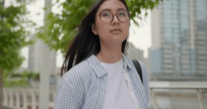 Young asian woman wearing casual clothes with backpack on the back walking at the city