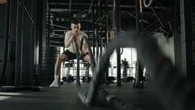 Determined Caucasian sportsman active athlete man bodybuilder training in gym muscular guy masculine workout with battle ropes sport equipment in fitness club physical exercise lifting weights effort - Powered by Shutterstock - Get 15% off with code: PIKWIZARD15