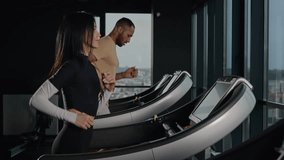Couple multiracial sportsman and sportswoman run on treadmill in fitness gym athletes woman and man runners jogging cardio exercise sprint jog workout on running machine in sport club active lifestyle - Powered by Shutterstock - Get 15% off with code: PIKWIZARD15