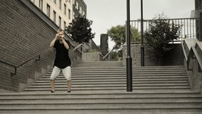 A man dances a dance with his hands. Dynamic camera, wide shot. Dancer in black clothes and shorts. - Powered by Shutterstock - Get 15% off with code: PIKWIZARD15