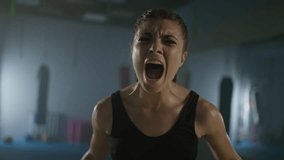 Portrait of a tired woman fighter, a screaming fighter looks into the camera after a hard fight in the boxing gym, woman power, 4k slow motion. - Powered by Shutterstock - Get 15% off with code: PIKWIZARD15