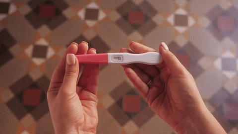 Woman with anxious feelings. Girl with a negative pregnancy test. Close-up of hands holding pregnancy test. 库存视频