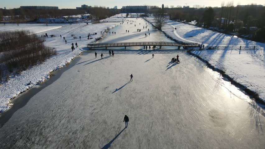 A popular ice skating spot in a scenic natural setting in the Netherlands on a sunny day.